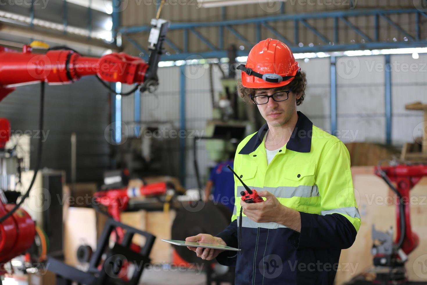 professionele industriële fabrieksmedewerker die met machineonderdelen werkt, industriële apparatuur en robotarmen controleert en test in een grote fabriek voor elektrische elektronica, draad- en kabelfabriek foto