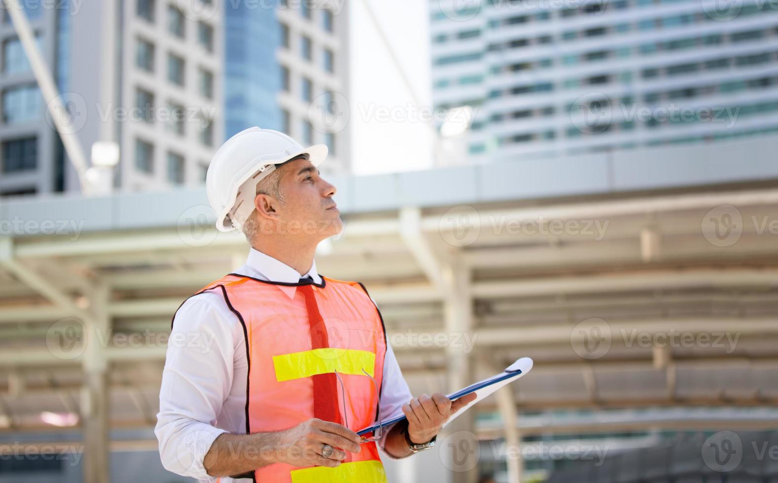 de ingenieur en zakenvrouw die op het klembord controleren bij de bouw van de bouwplaats. het concept van engineering, constructie, stadsleven en toekomst. foto