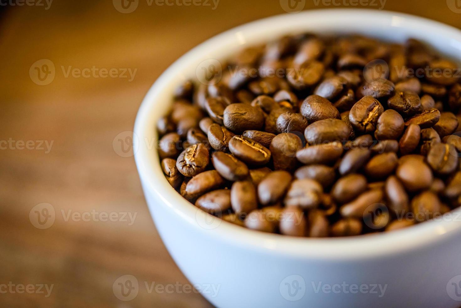 koffiebonen in cup op houten grunge achtergrond foto