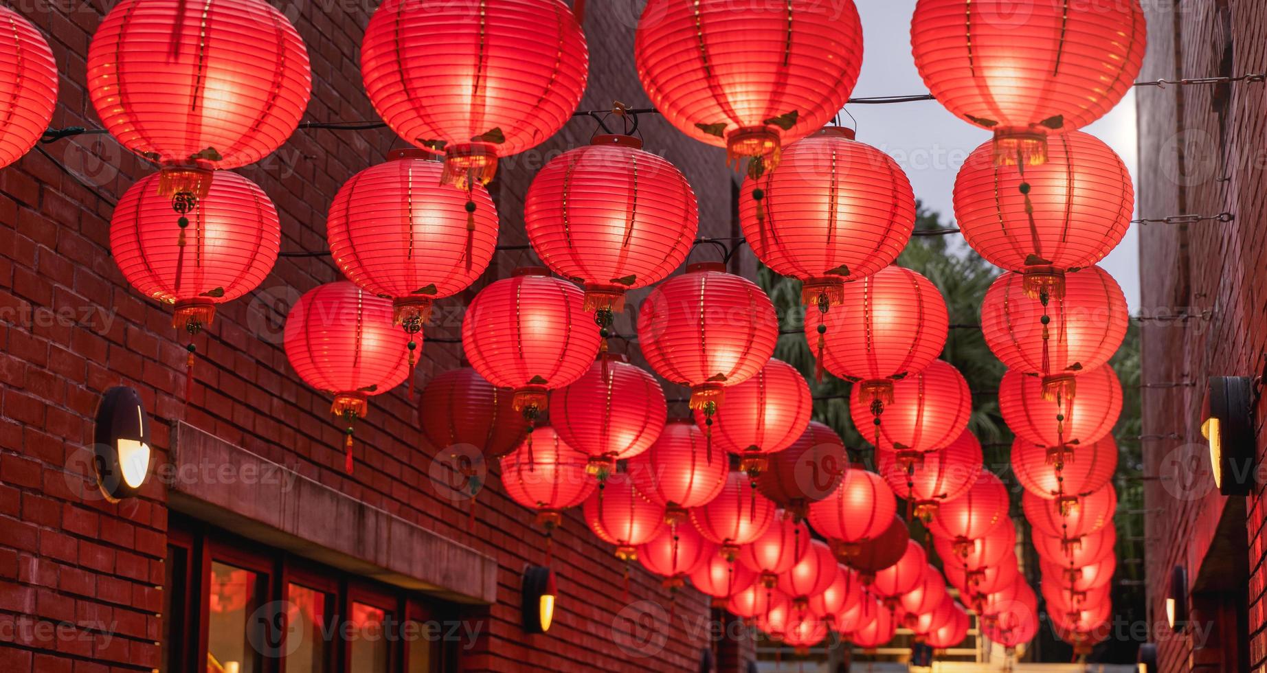 mooie ronde rode lantaarn die op oude traditionele straat hangt, concept van Chinees maannieuwjaarsfestival, close-up. het onderliggende woord betekent zegen. foto