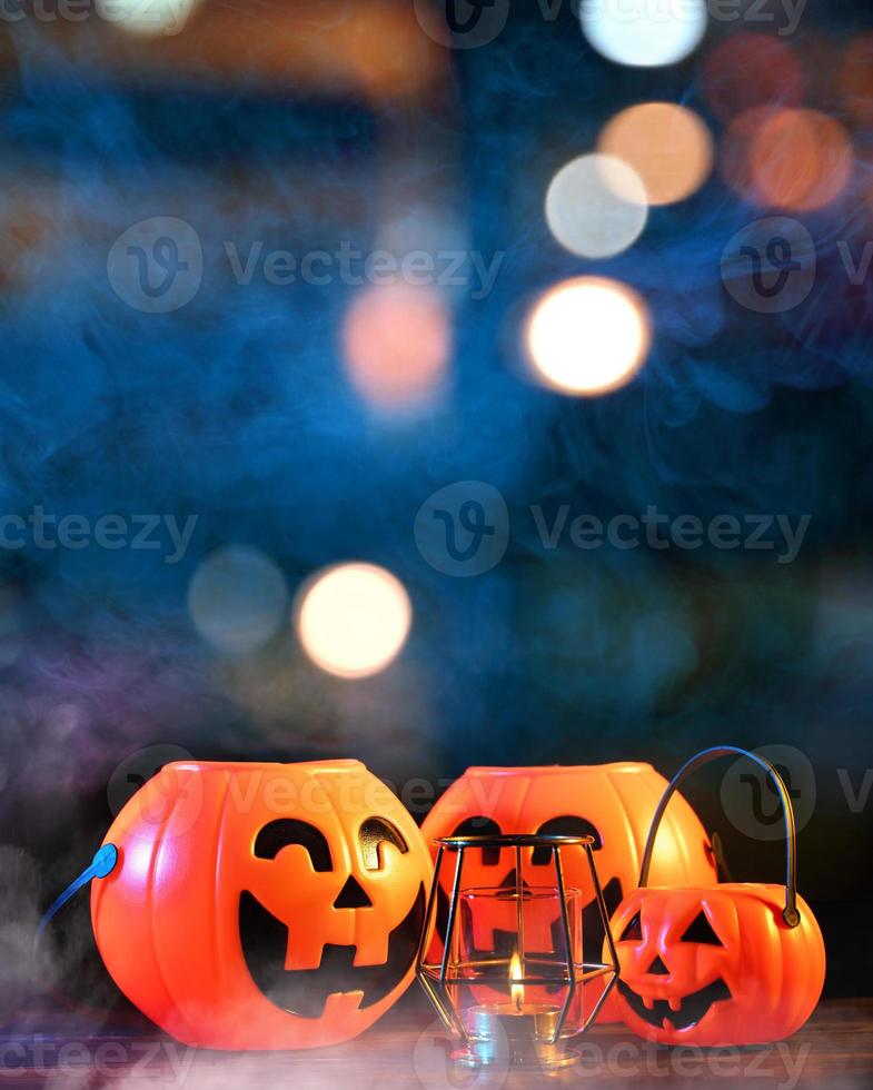 halloween concept - oranje plastic pompoenlantaarn op een donkere houten tafel met wazig sprankelend licht op de achtergrond, trick or treat, close-up. foto