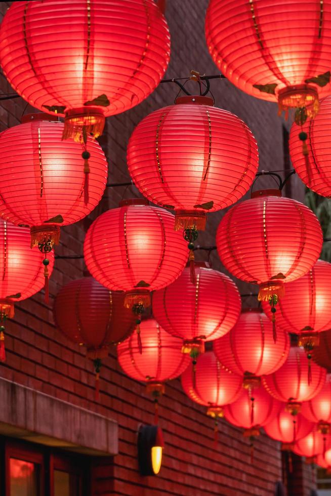 mooie ronde rode lantaarn die op oude traditionele straat hangt, concept van Chinees maannieuwjaarsfestival, close-up. het onderliggende woord betekent zegen. foto