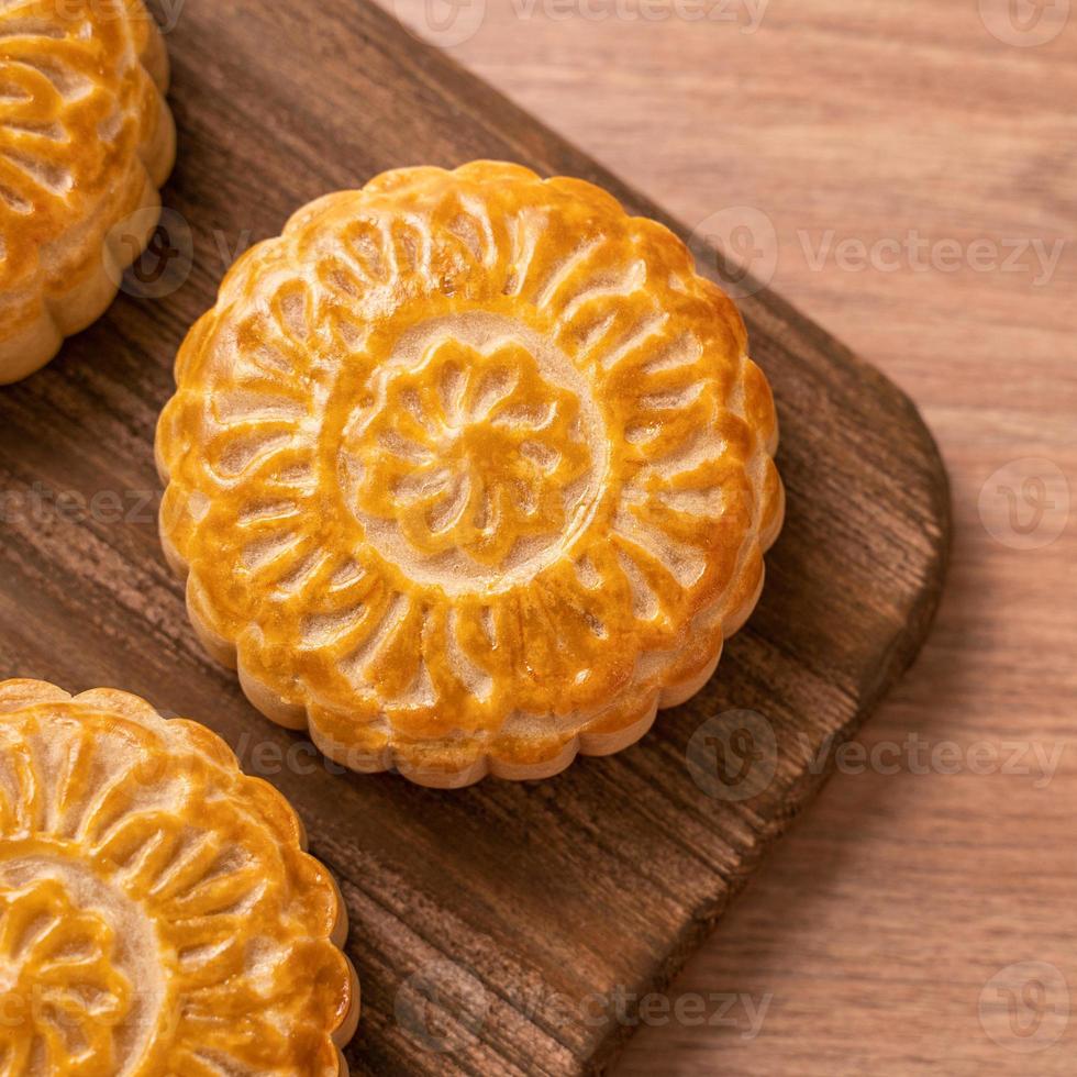 ronde vormige vers gebakken maan cake gebak - chinese moonckae voor mid-herfst maan festival op houten achtergrond en dienblad, bovenaanzicht, plat lag. foto