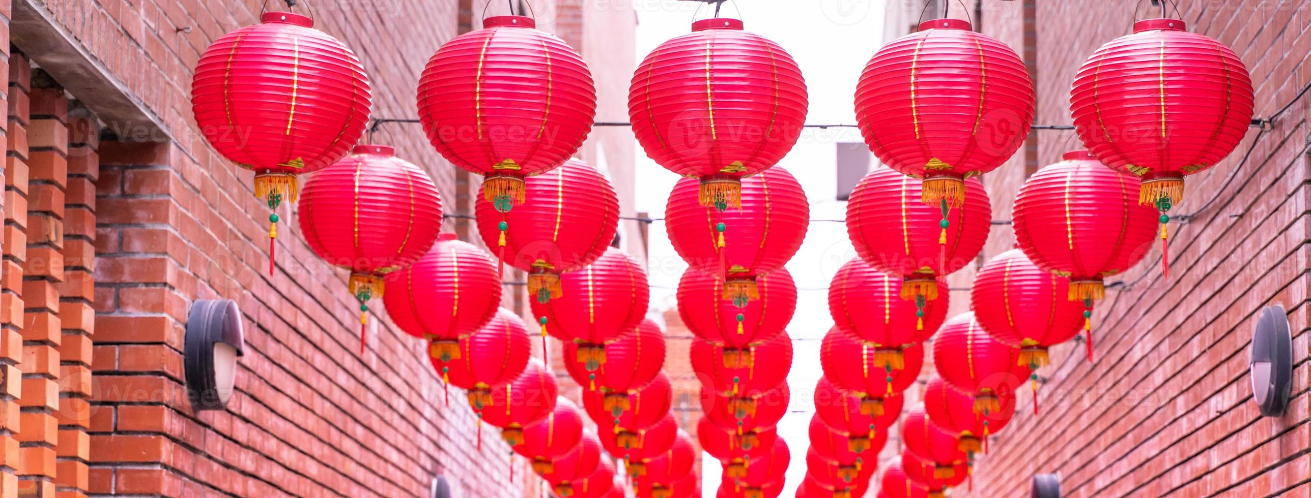 mooie ronde rode lantaarn die op oude traditionele straat hangt, concept van Chinees maannieuwjaarsfestival, close-up. het onderliggende woord betekent zegen. foto