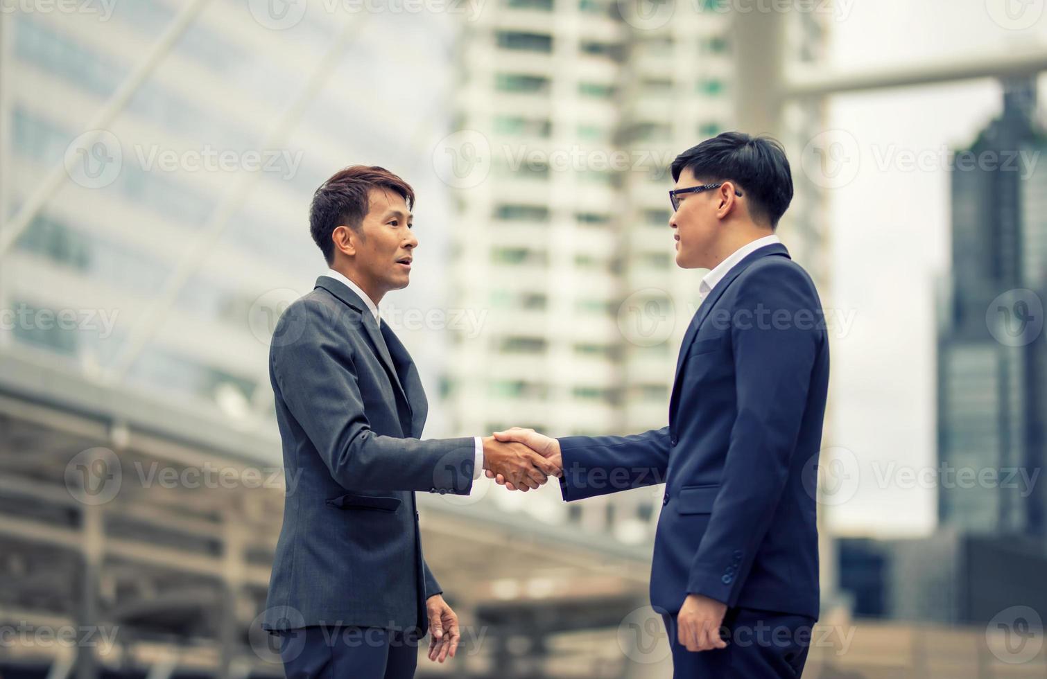 zakenman handdruk voor teamwork van zakelijke fusie en overname, succesvol onderhandelen, hand schudden, twee zakenman schudden de hand met partner om partnerschap en zakelijke deal concept te vieren foto