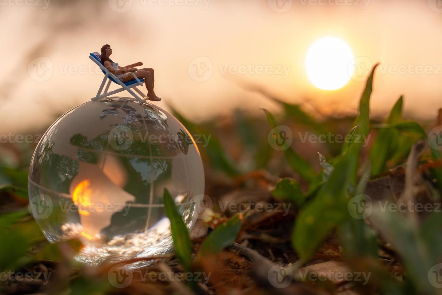 miniatuur mensen zonnebaden op kristallen bol in het park foto