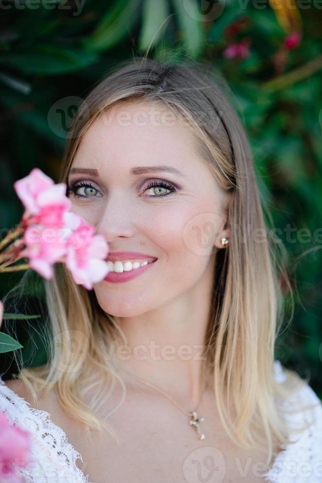 mooi model meisje, met bloemen pioenroos in de buurt van het gezicht. cosmetica, schoonheid, make-up, bruiloft en cosmetologie. foto