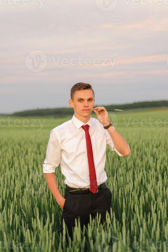 bruid en bruidegom in een tarweveld. het paar knuffelt tijdens zonsondergang foto