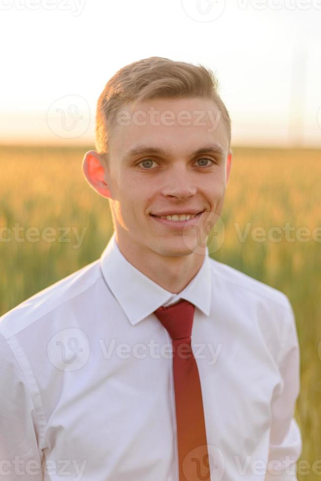 bruid en bruidegom in een tarweveld. het paar knuffelt tijdens zonsondergang foto