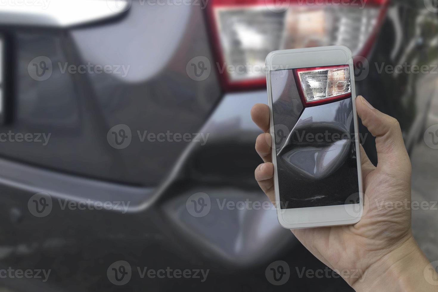 hand met smartphone maak een foto op de plaats van een auto-ongeluk, auto-ongeluk voor verzekering