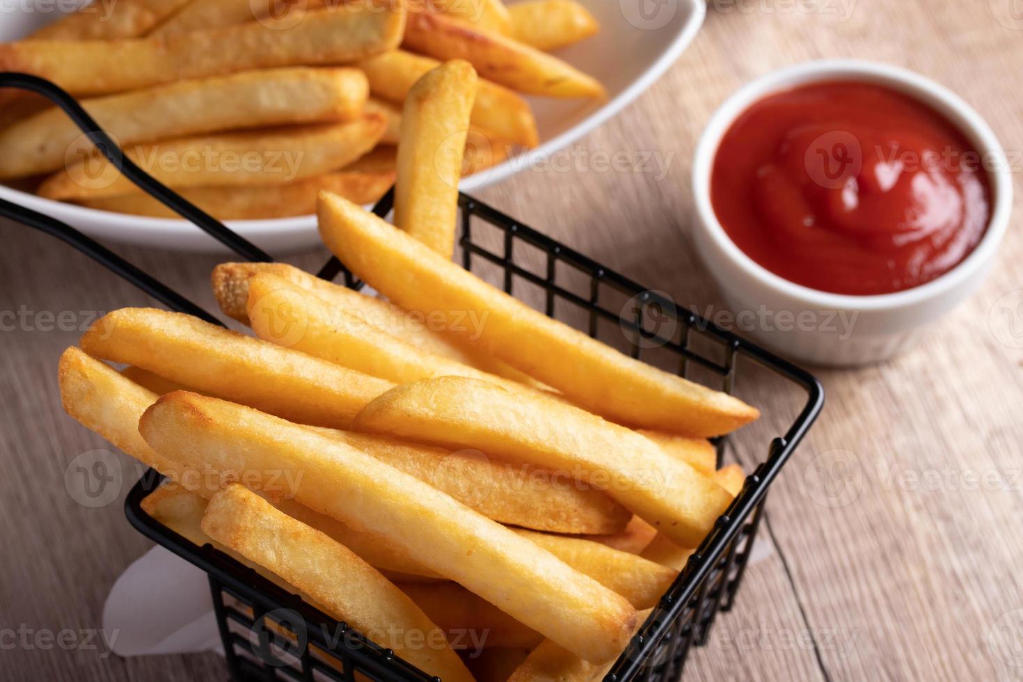 frietjes in een zwarte mand met tomatensaus foto