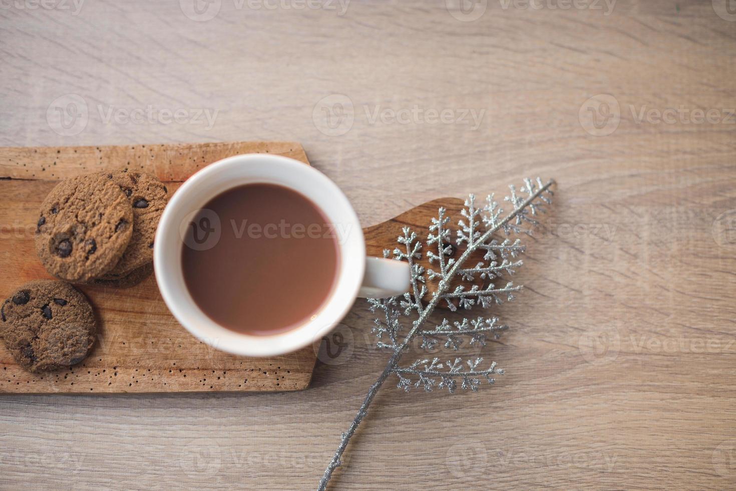 een kop warme chocolademelk en koekjes op houten dienblad voor winterachtergrond foto