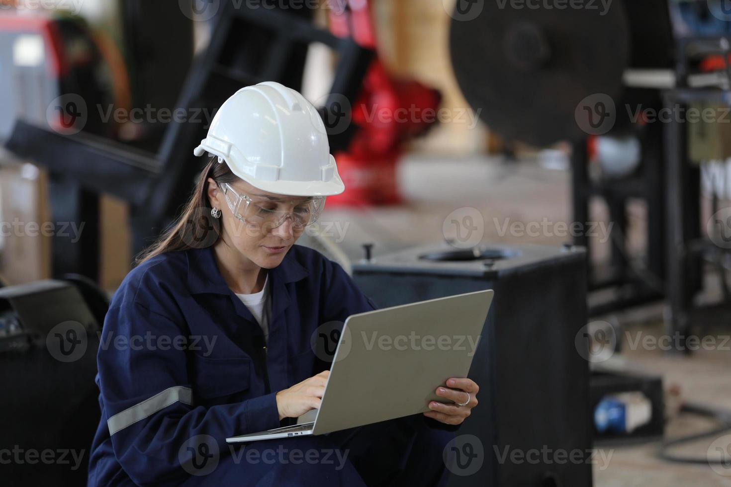 diverse multiculturele ingenieurs en arbeiders in de zware industrie in uniforme robotarmen met automatische cheques voor gebruik in de fabriek. vrouwelijke industriële aannemer gebruikt een tabletcomputer. foto