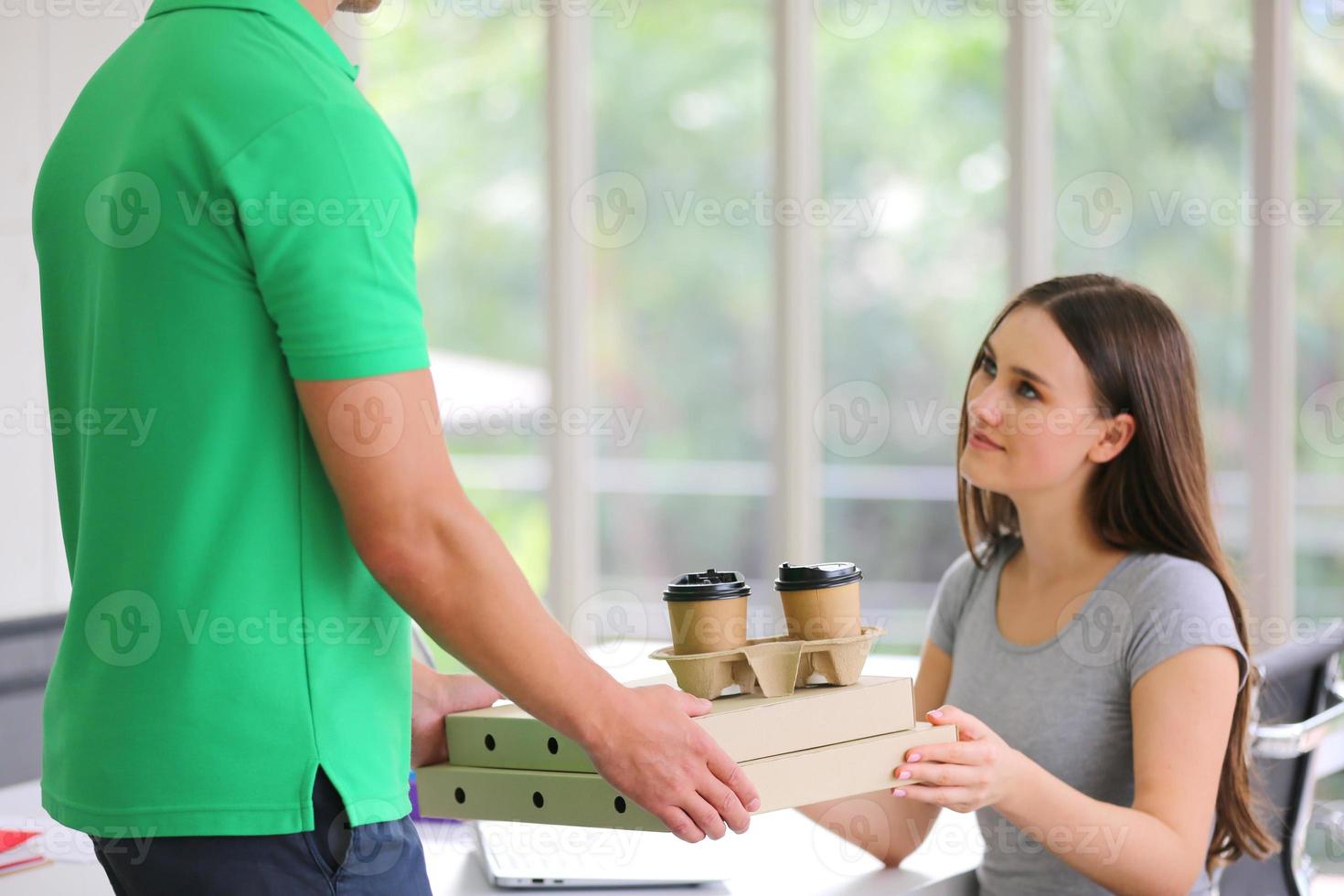 jonge man bezorgde het pakket. koerier met een kartonnen doos. pakketbezorgdienst. foto