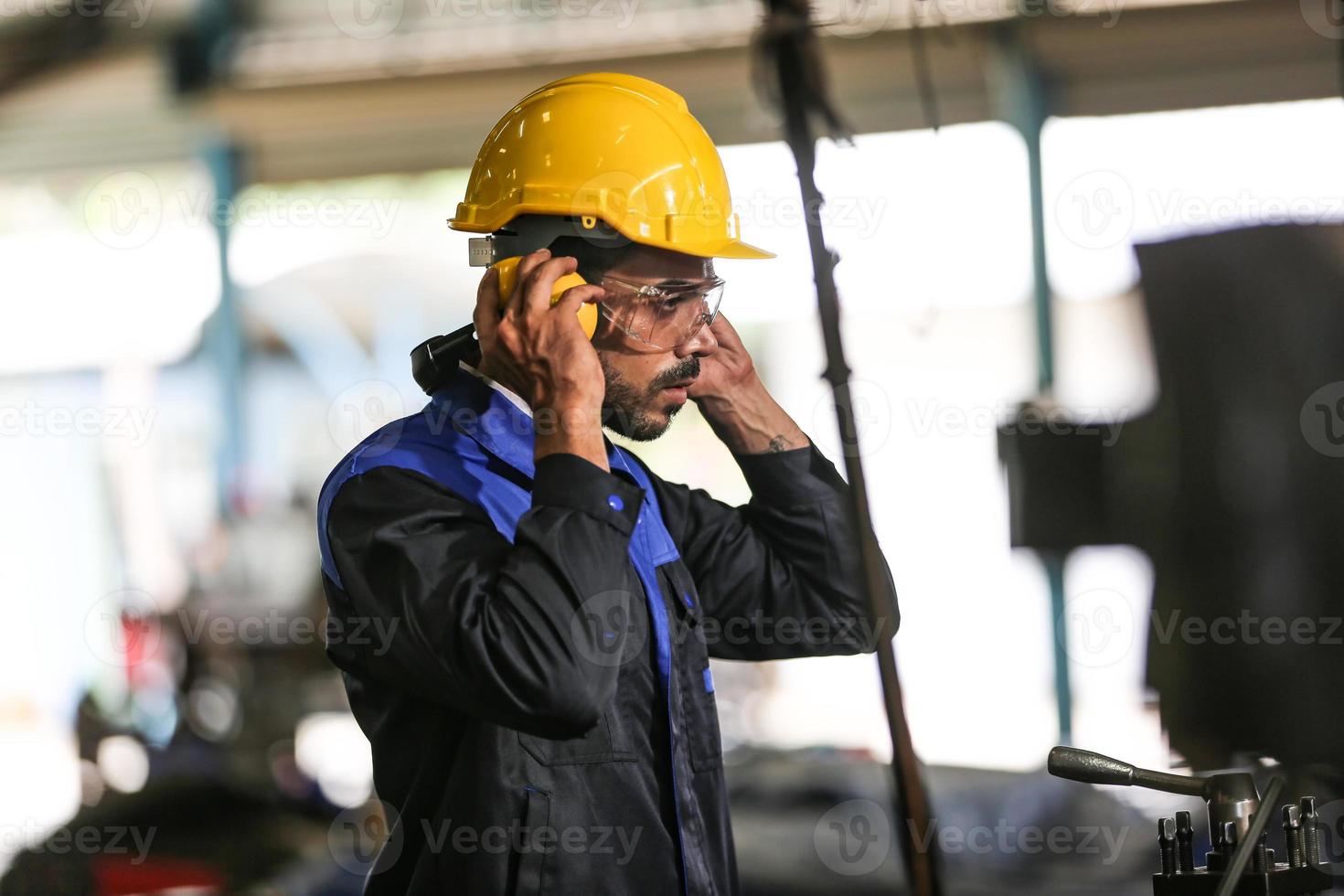 professionele industriële fabrieksmedewerker die met machineonderdelen werkt, industriële apparatuur en robotarmen controleert en test in een grote fabriek voor elektrische elektronica, draad- en kabelfabriek foto