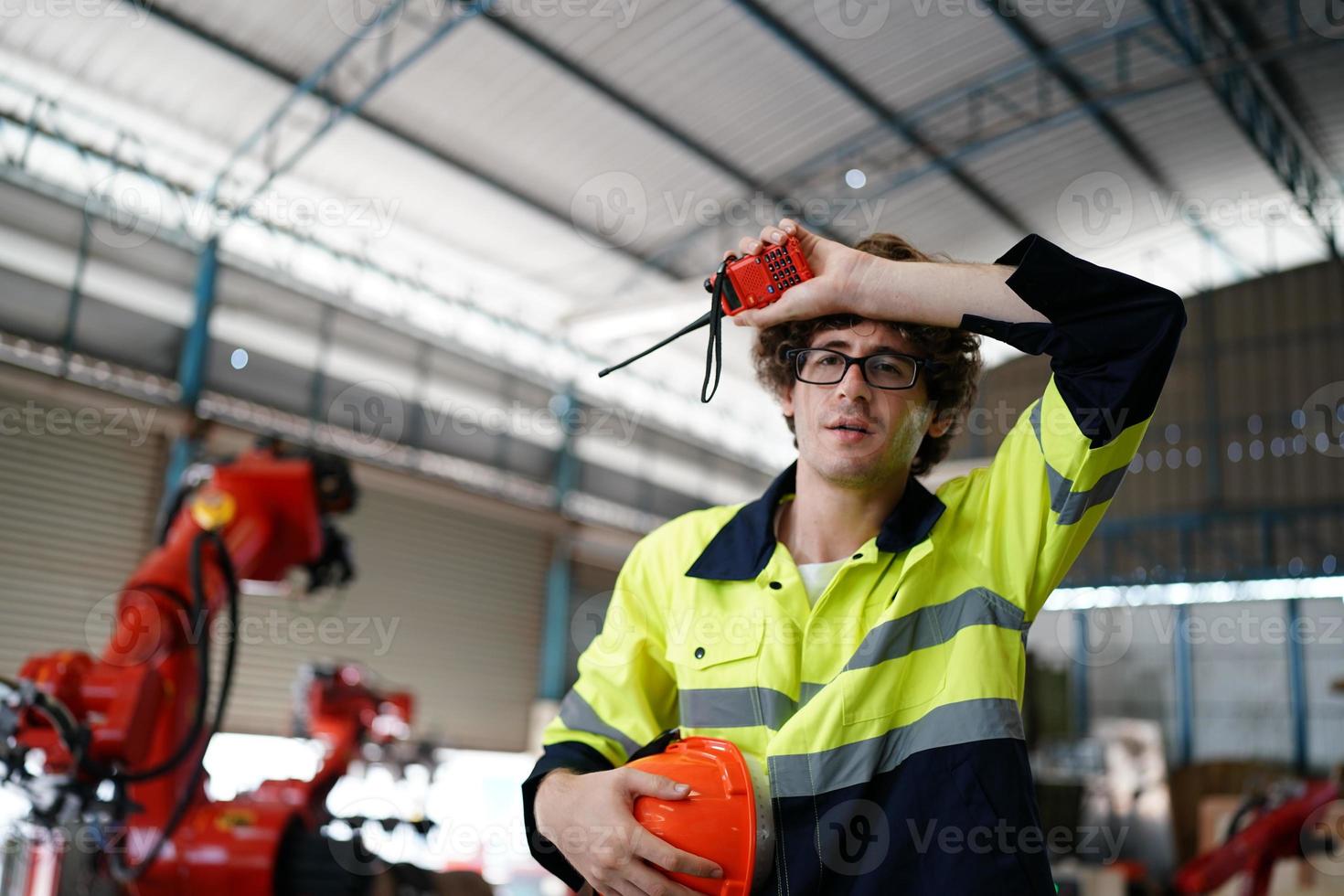 professionele industriële fabrieksmedewerker die met machineonderdelen werkt, industriële apparatuur en robotarmen controleert en test in een grote fabriek voor elektrische elektronica, draad- en kabelfabriek foto