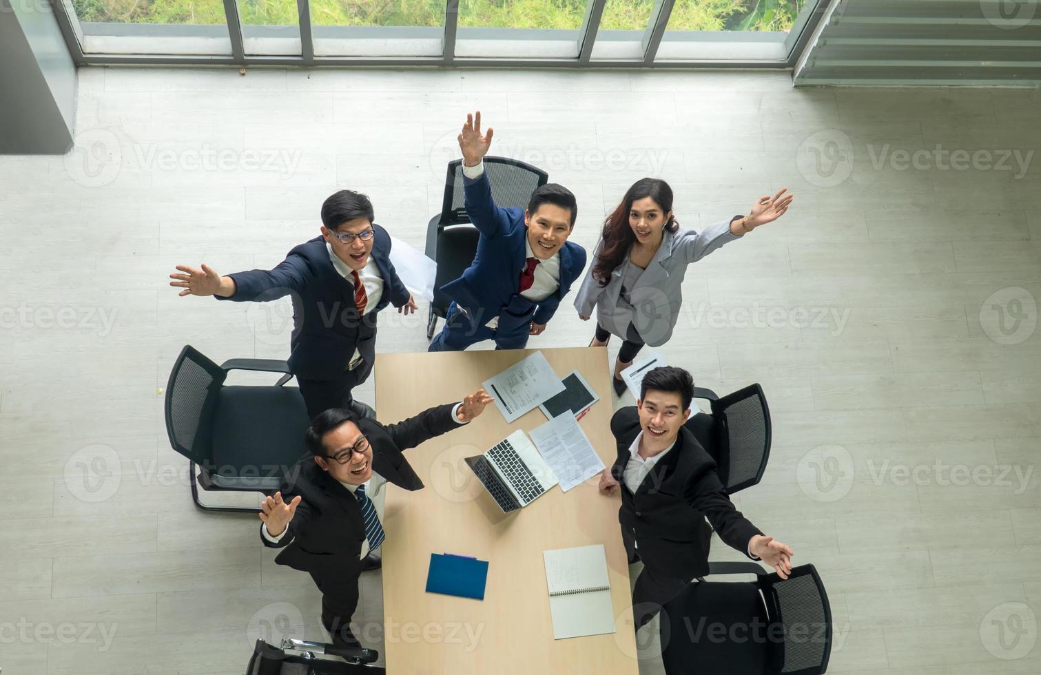 bovenaanzicht op een groep zakenman en zakenvrouw die een vergadering heeft en een zakelijke verbintenis aangaat. foto
