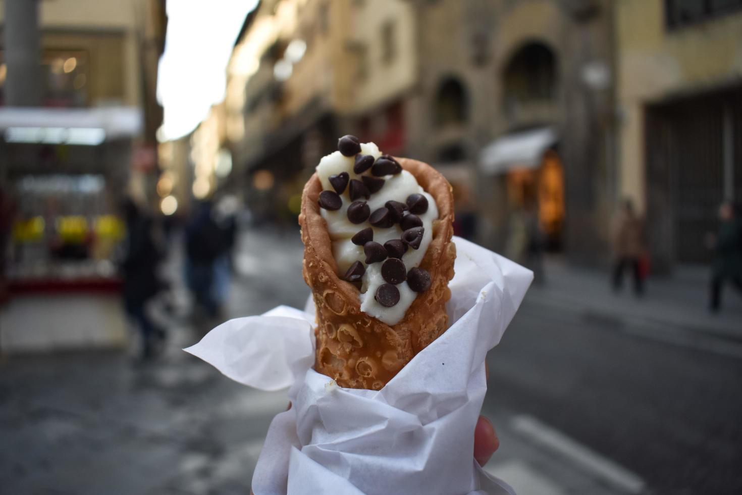 cannoli met chocoladeschilfers met een soft focus achtergrond van florence, italië straat foto