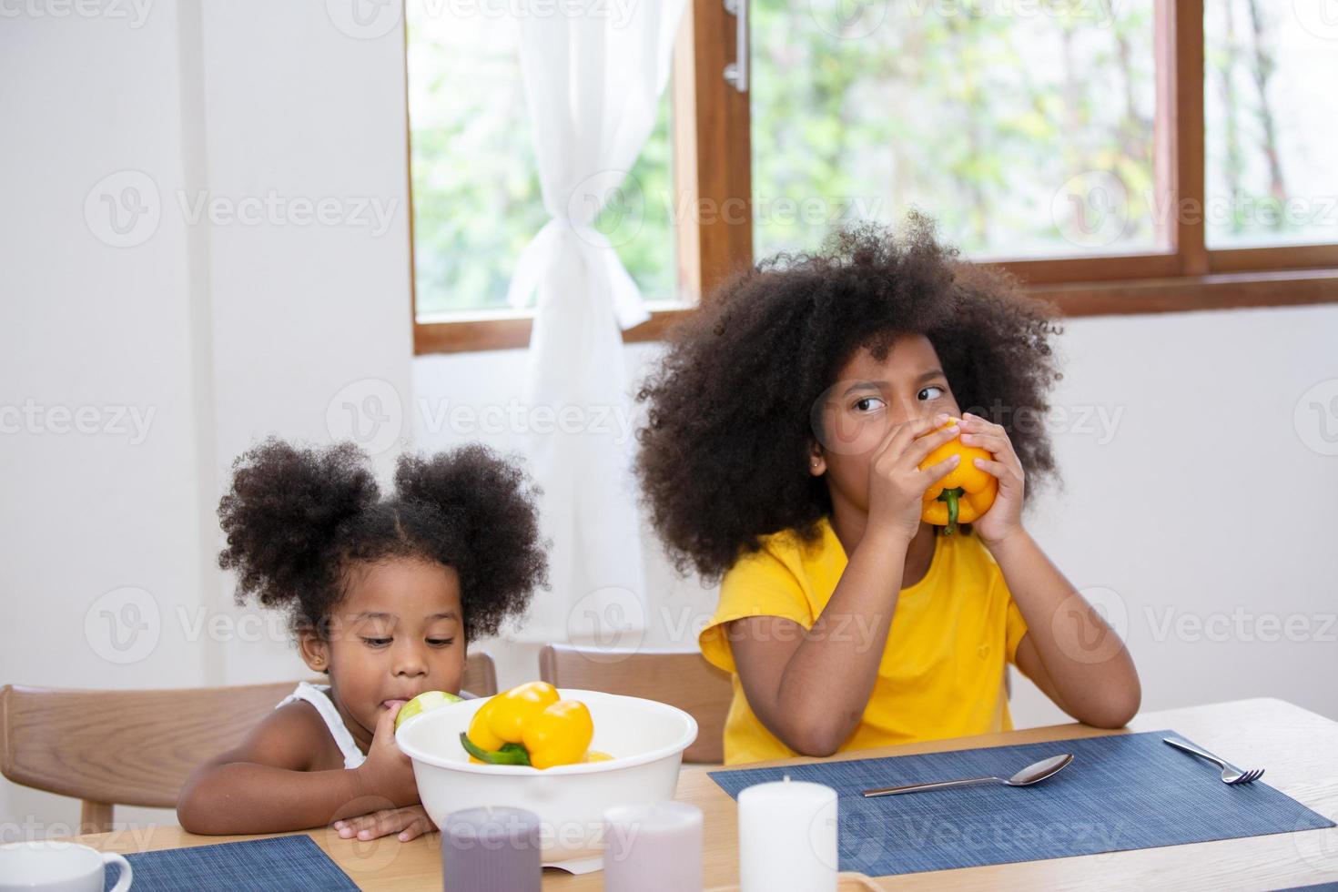 gelukkig gemengd ras multinationale familie met dochters bereiden plantaardige biologische verse salade, genieten van tijdverdrijf kookproces in een gezellige keuken, gezond eten, ouders leren kinderen, weekend thuis activiteit foto