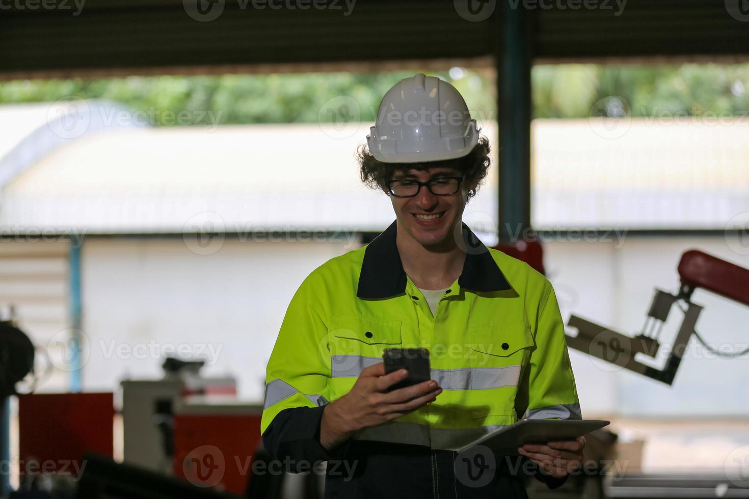 professionele industriële fabrieksmedewerker die met machineonderdelen werkt, industriële apparatuur en robotarmen controleert en test in een grote fabriek voor elektrische elektronica, draad- en kabelfabriek foto