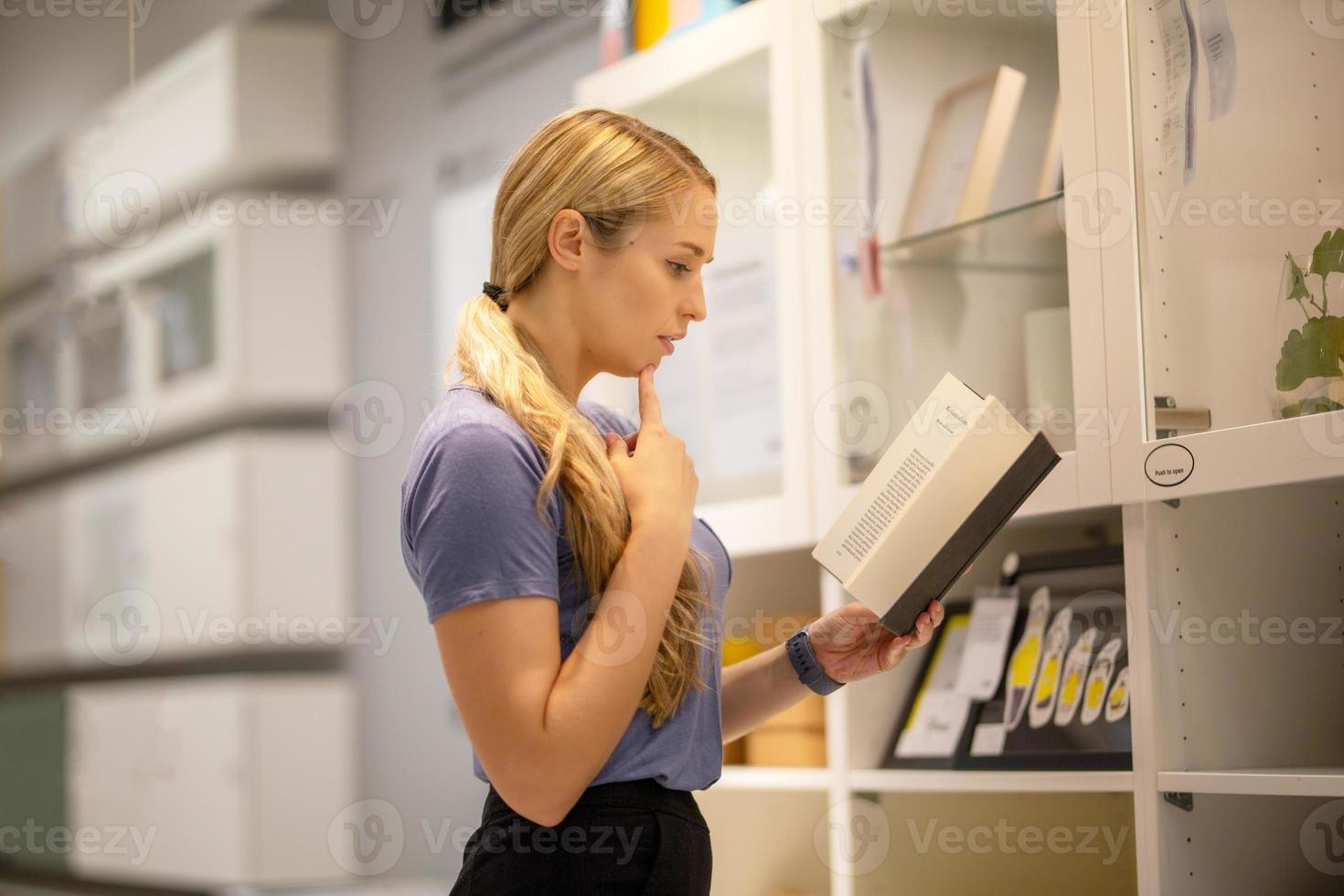 zijaanzicht van vrouwen op zoek naar iets op boekenplank foto