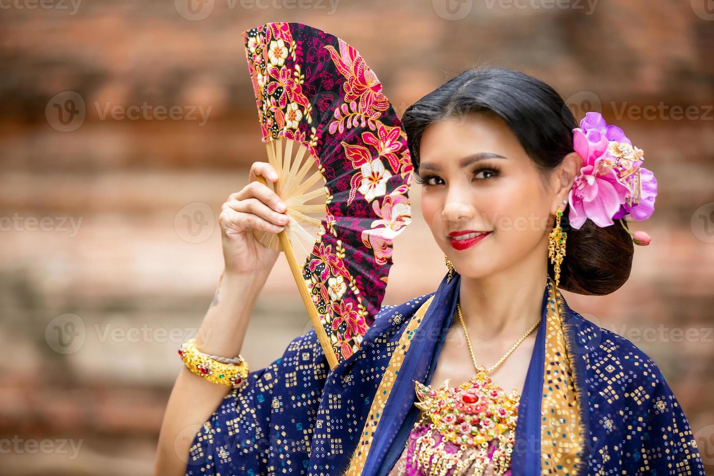 jonge Aziatische vrouwen in klederdracht in de boot en roze lotusbloemen in de pond.beautiful meisjes in klederdracht.thai meisje in retro thaise jurk, thais meisje in klederdracht foto