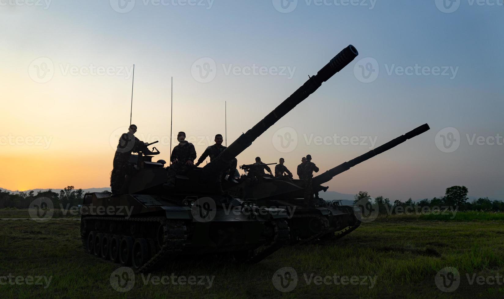 silhouetten van legersoldaten in de mist tegen een zonsondergang, mariniersteam in actie, omringd door vuur en rook, schietend met aanvalsgeweer en machinegeweer, aanvallende vijand foto
