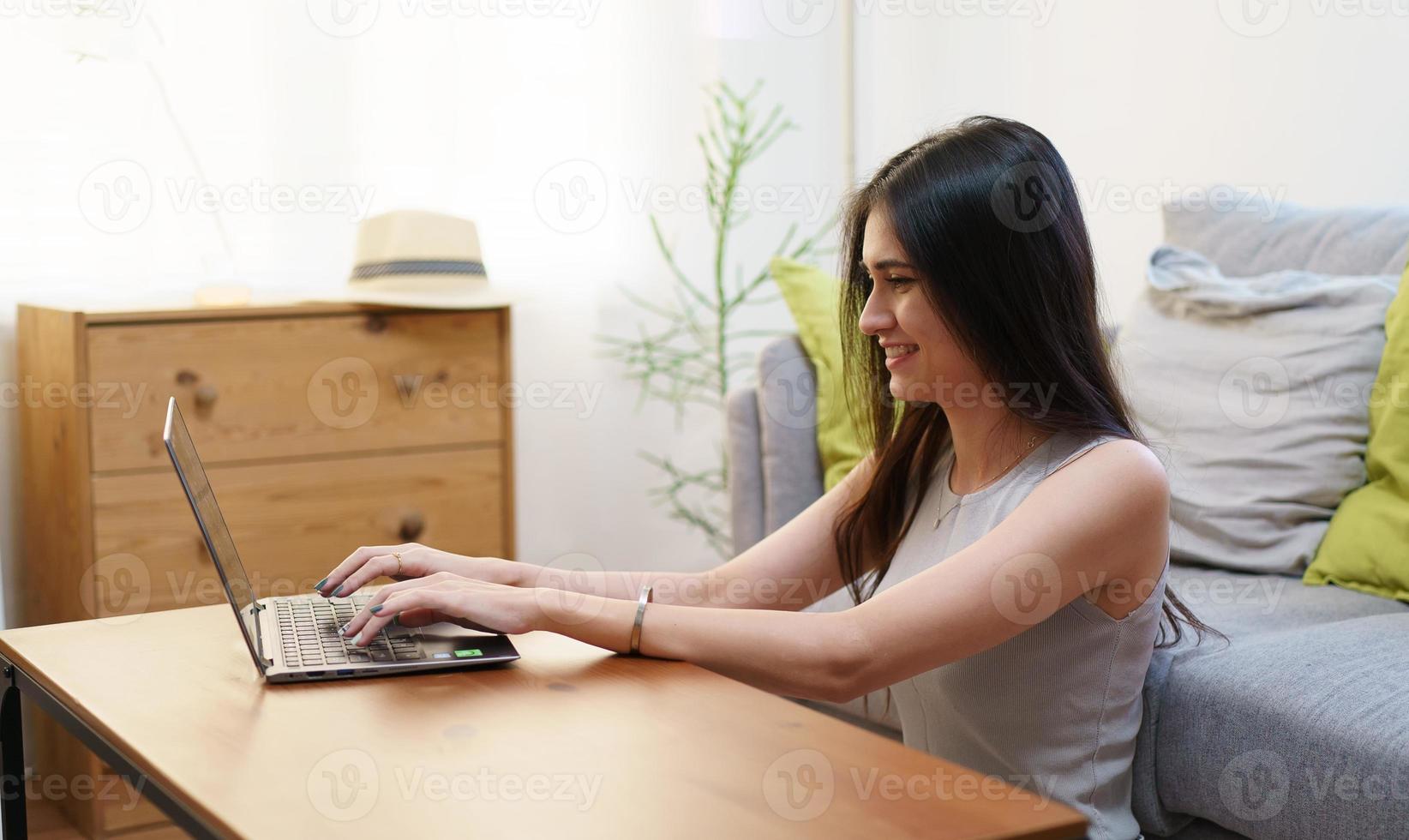 jonge mooie vrouw met behulp van een laptop thuis foto