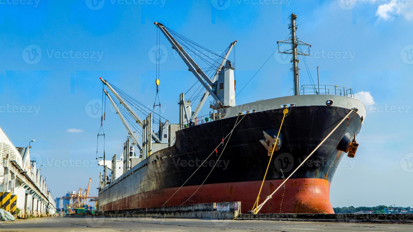 container laden in een vrachtschip met industriële kraan. containerschip in logistiek bedrijf voor import en export. industrie en transport concept. foto