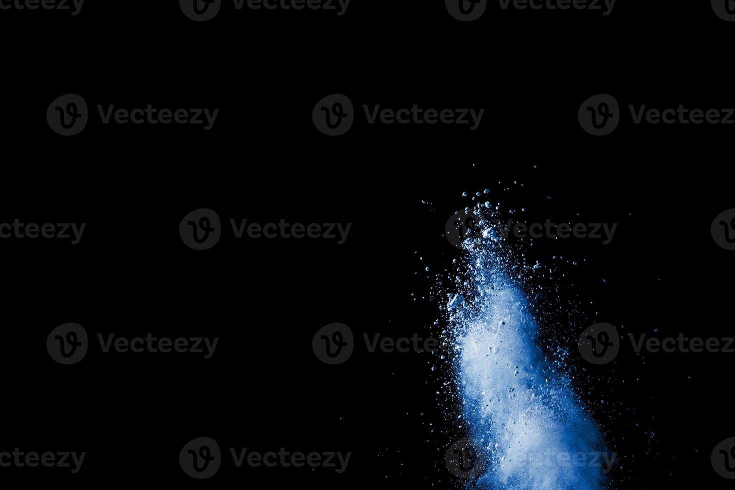 abstracte blauwe stofexplosie op zwarte achtergrond. blauw poeder spetterde op zwarte achtergrond. bevriezen beweging van blauwe poeder splash. foto