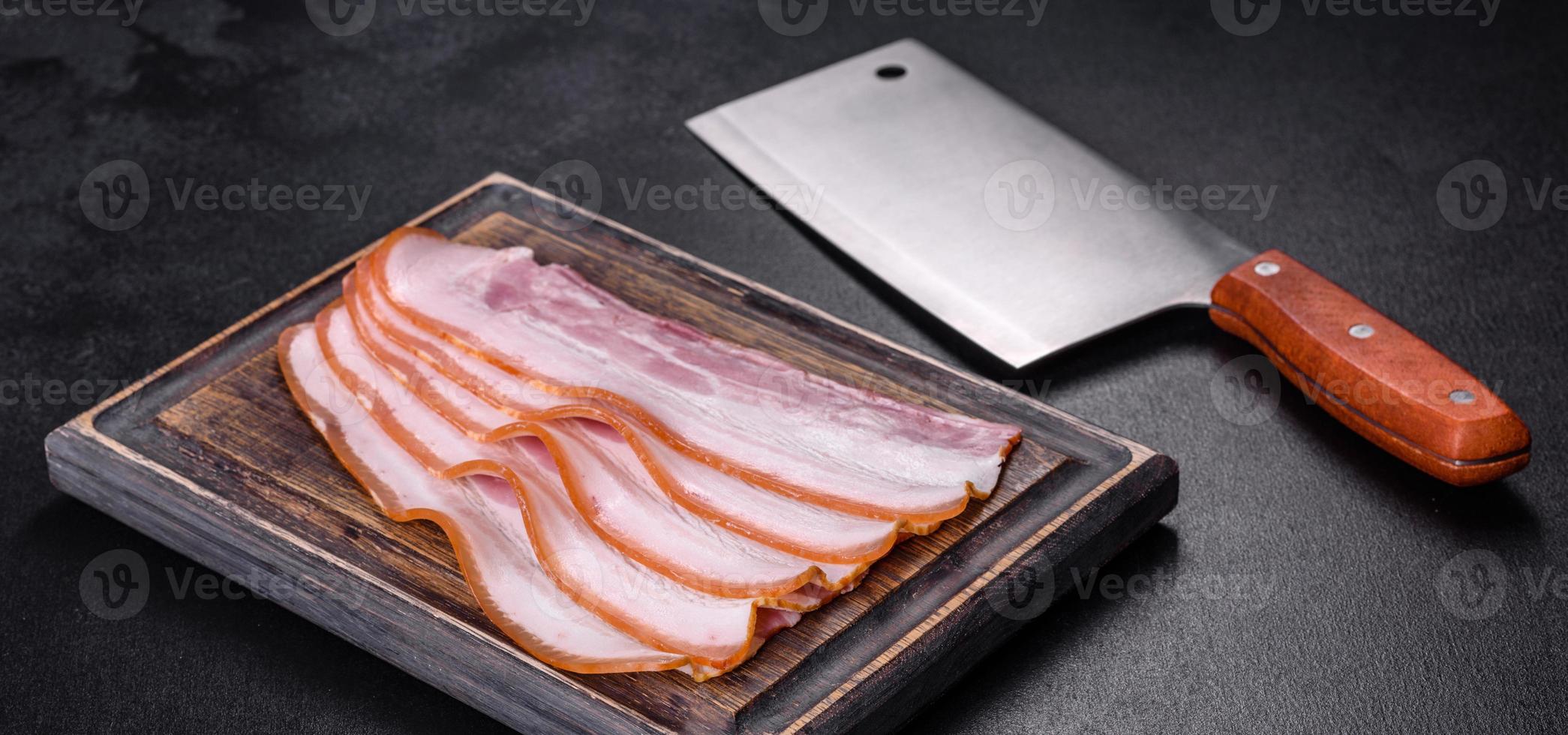 plakjes spek op een houten snijplank. varkensvlees foto