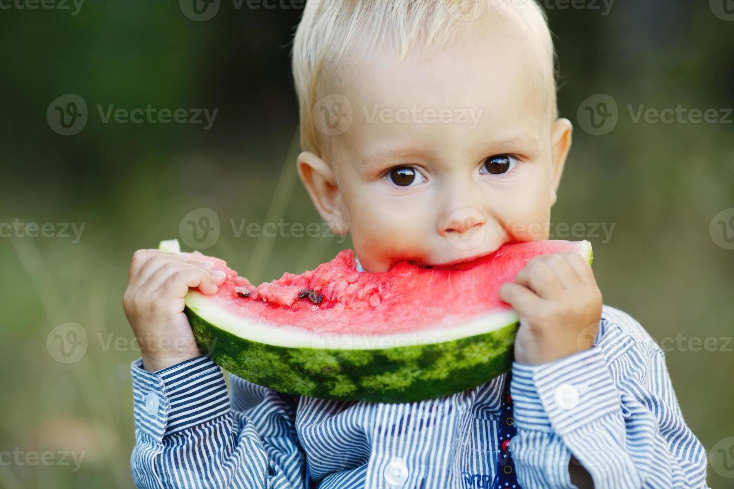 kleine jongen eet watermeloen foto