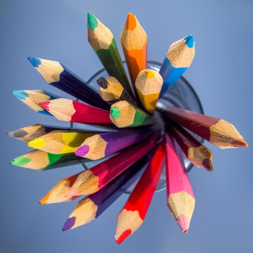 een groep kleurpotloden in een glazen beker foto