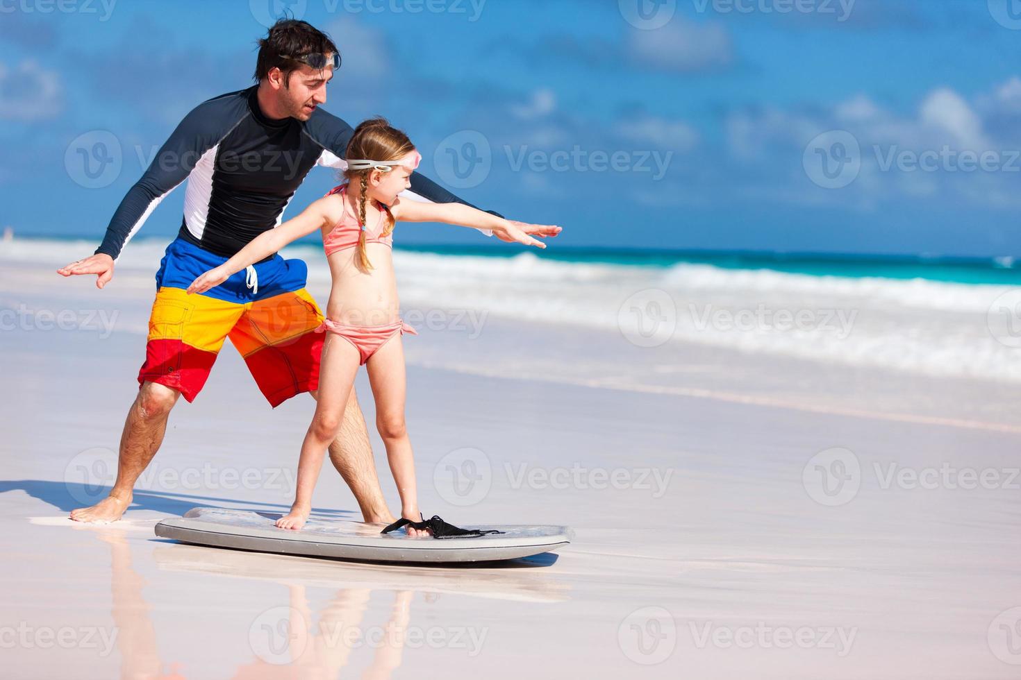 vader en dochter oefenen surfen foto