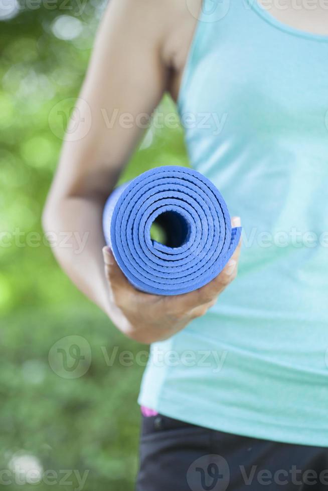 jonge vrouw met een yogamat foto