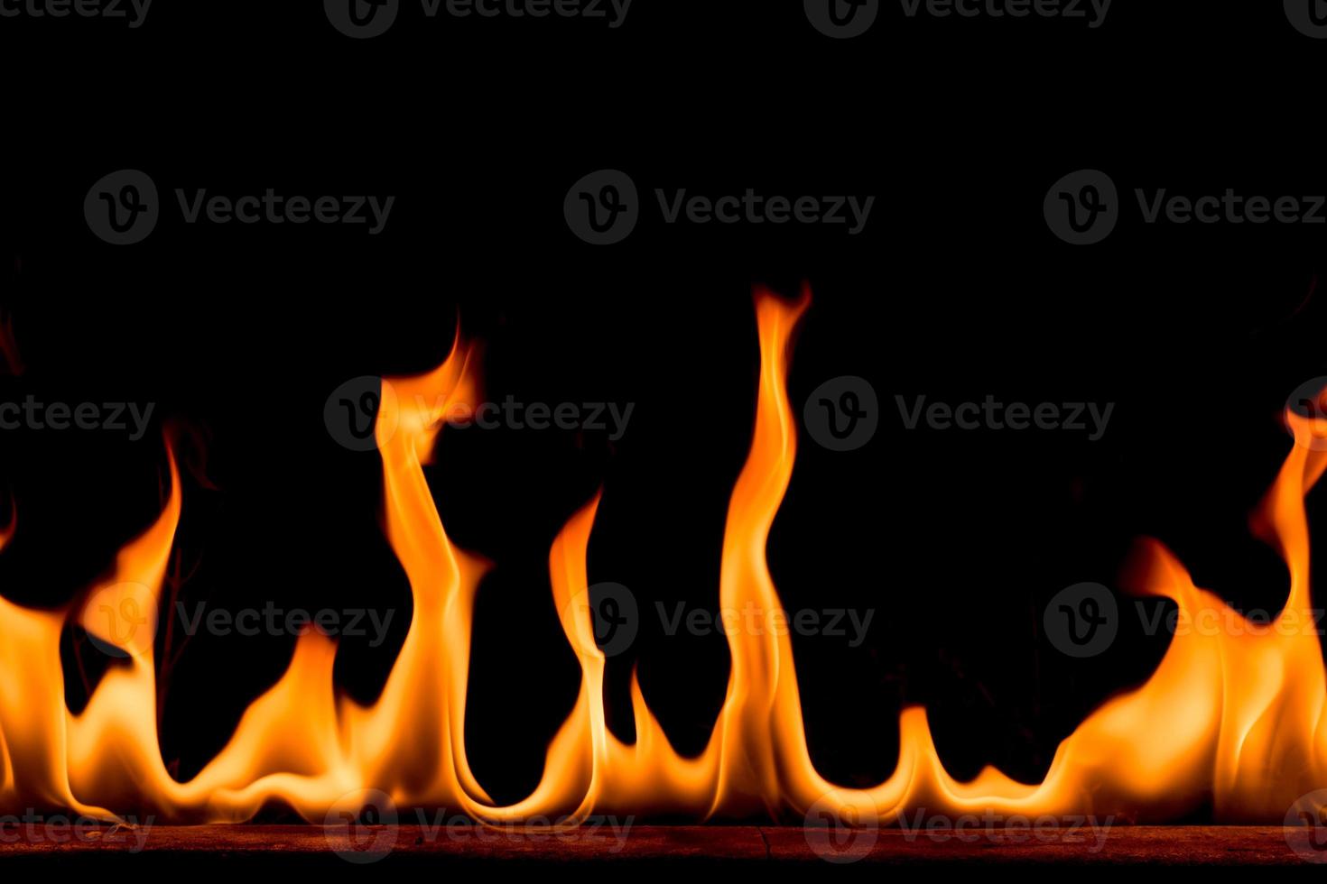 natuur vuur vlammen op zwarte achtergrond. bevriezen beweging van rood-gele vuur vlammen branden in de donkere nacht. foto