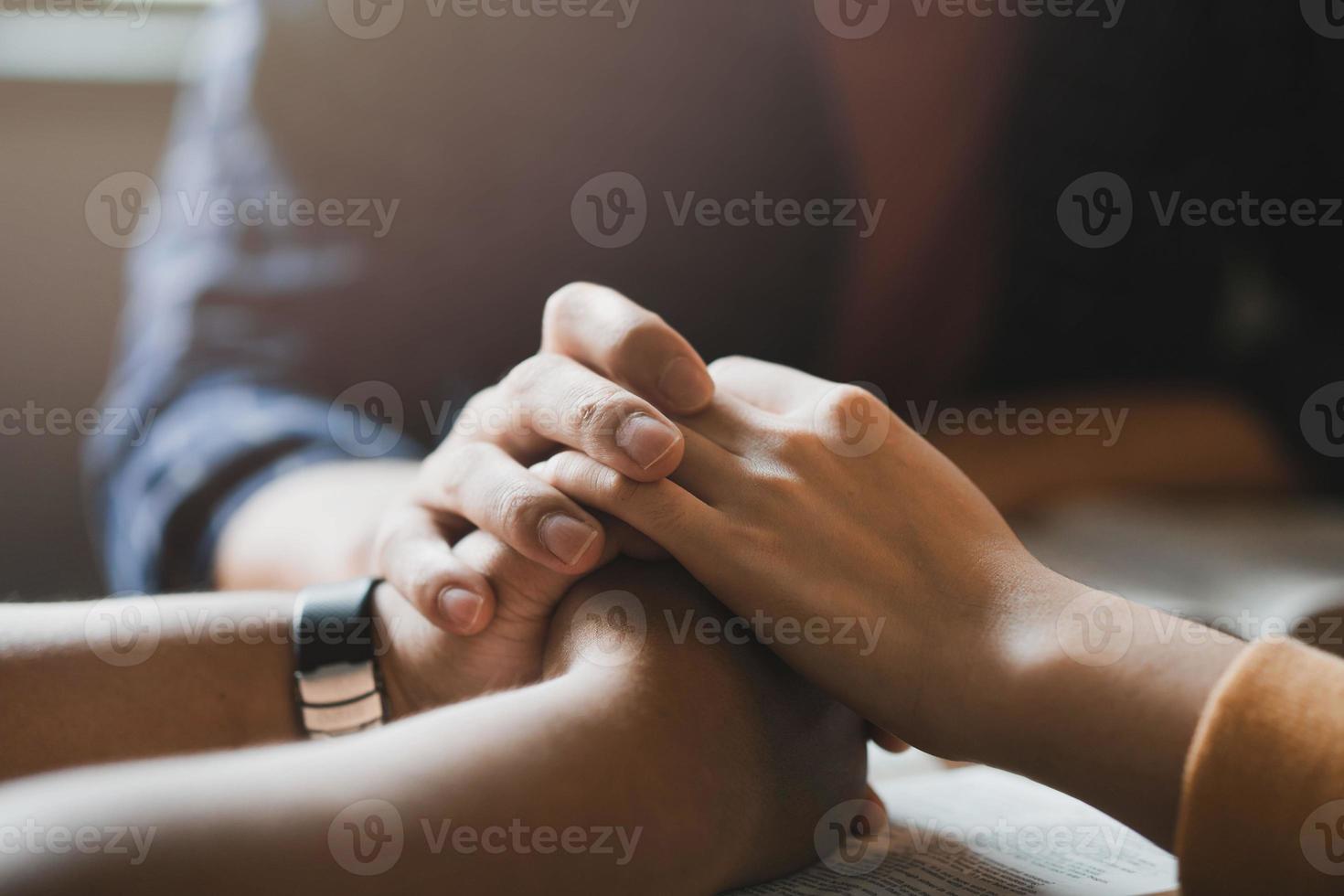 een groep mensen zit en bidt voor degenen die ontmoedigd en wanhopig zijn om hoop te geven aan hun broeders en zusters. klaar om elkaars hand vast te houden in gebed om het geloof te zegenen foto