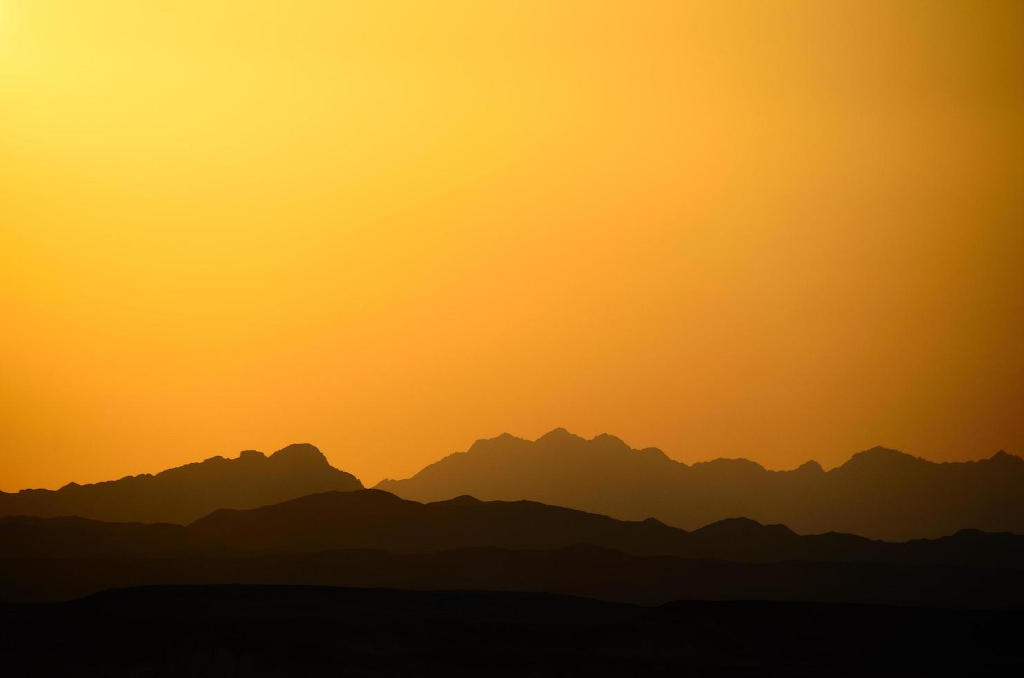 verschillende bergen en oranje lucht foto