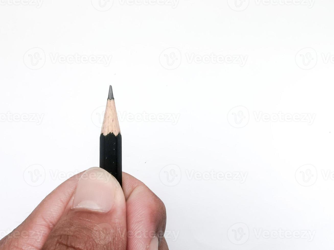 hand met een zwart potlood klaar om iets op papier te schrijven foto
