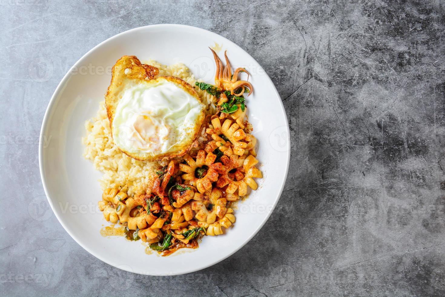 pittige roergebakken inktvis met basilicumblaadjes en chili, sunny side up ei foto