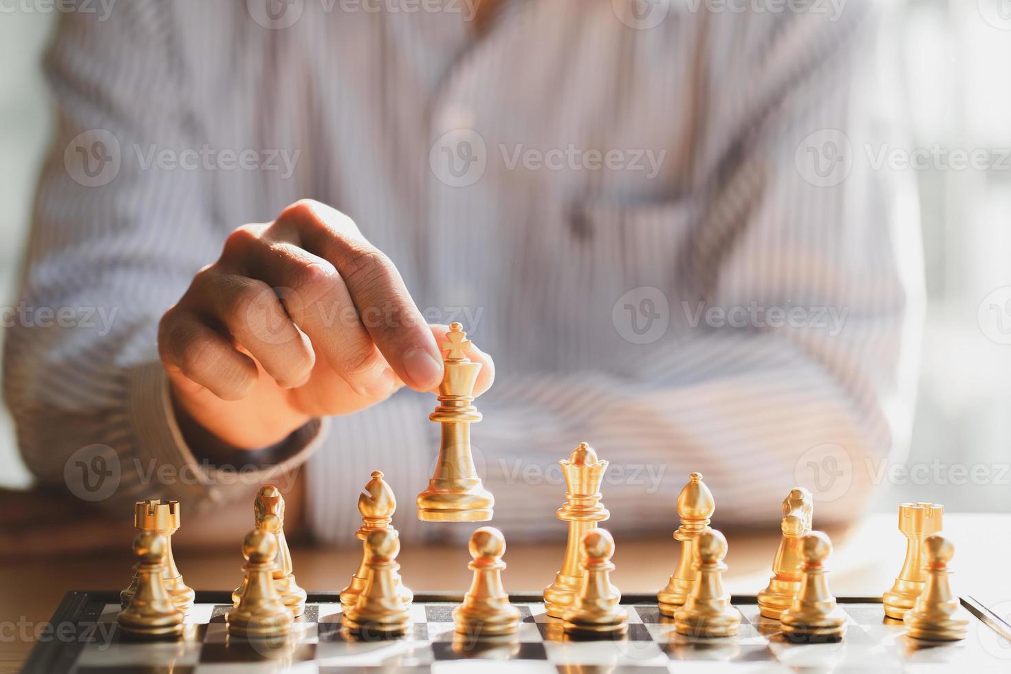 zakenman hand bewegende gouden schaakkoning figuur en schaakmat tegenstander tijdens schaakbord competitie. strategie, succes, management, bedrijfsplanning, disruptie en leiderschapsconcept foto