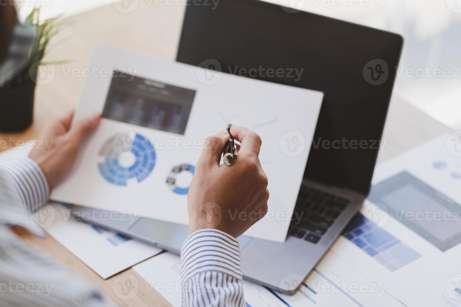 zakenman aan het werk op laptop computer holding en analyse van bedrijfsgegevens, marktaandeelrapport, informatiebeoordeling, bedrijfsstrategieanalyseconcept. foto