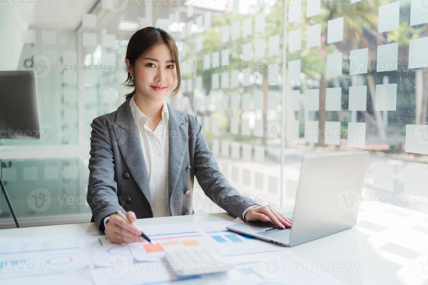 aziatische vrouw die op kantoor werkt met een laptop. foto