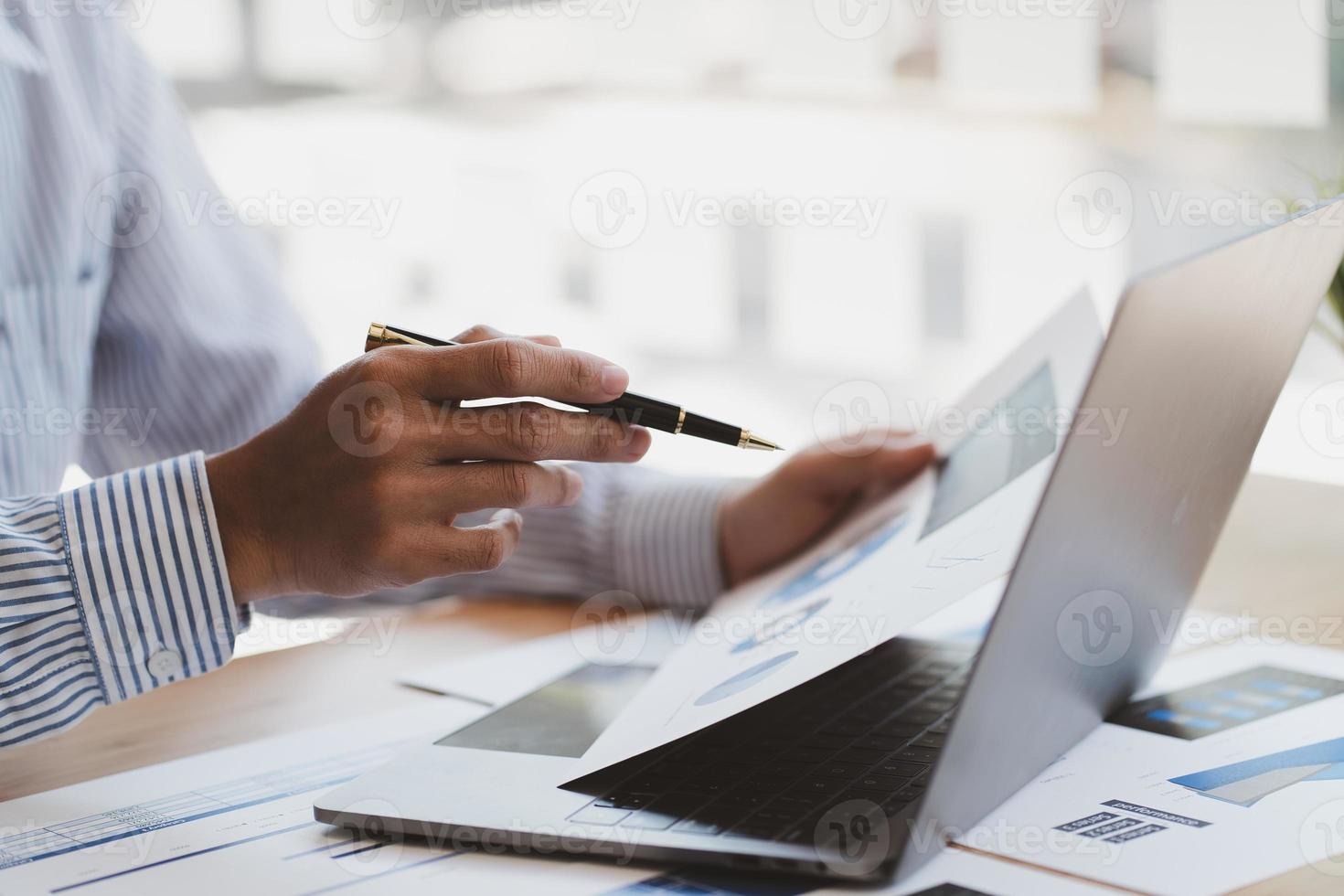 manager gebruikt een laptop terwijl hij de financiële overzichten van het bedrijf op het scherm analyseert. foto