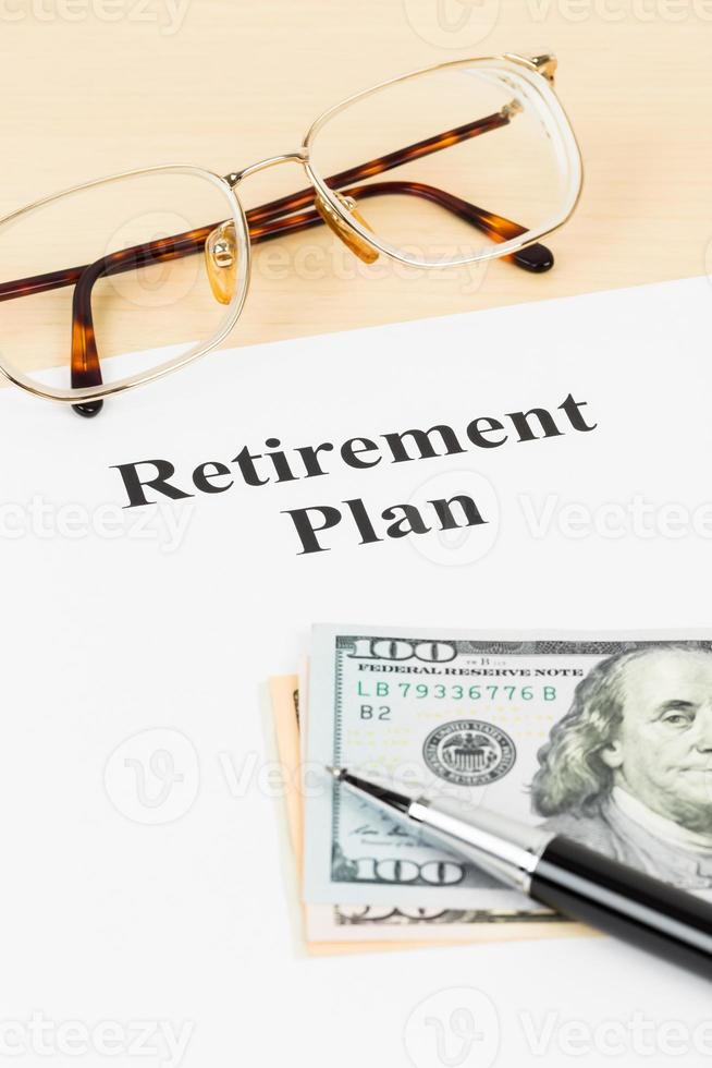 pensioenplan met bankbiljet, bril en pen foto