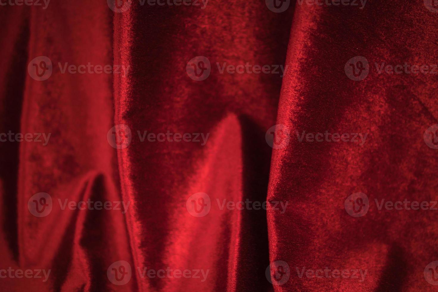 vouw zacht zwaaide rode velours stof getextureerde achtergrond. foto