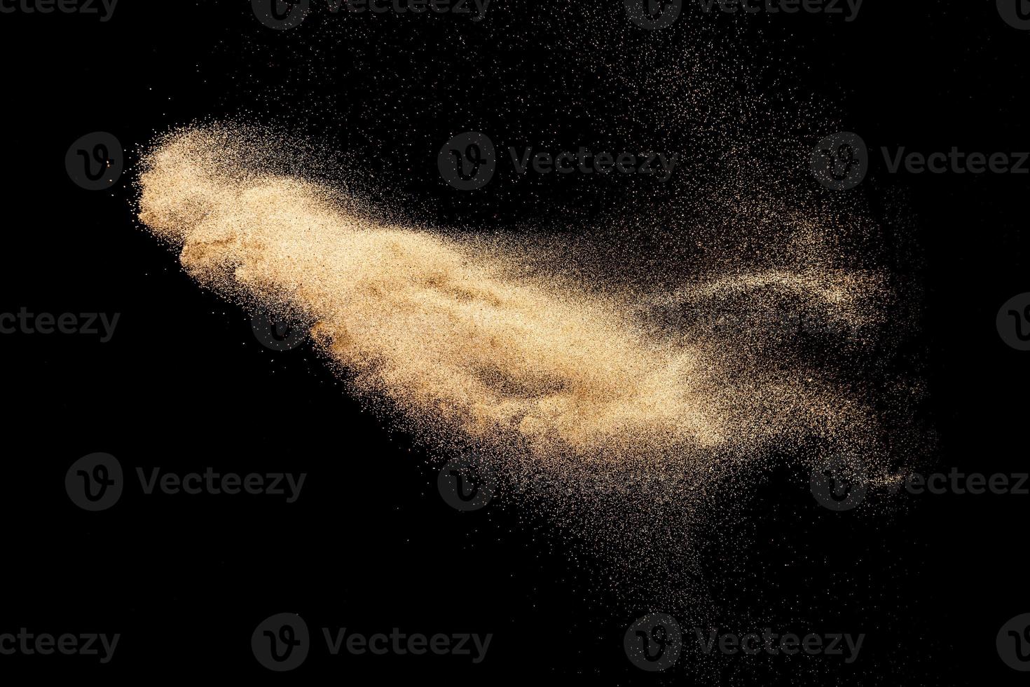 bruine kleur zand splash tegen zwarte achtergrond. foto