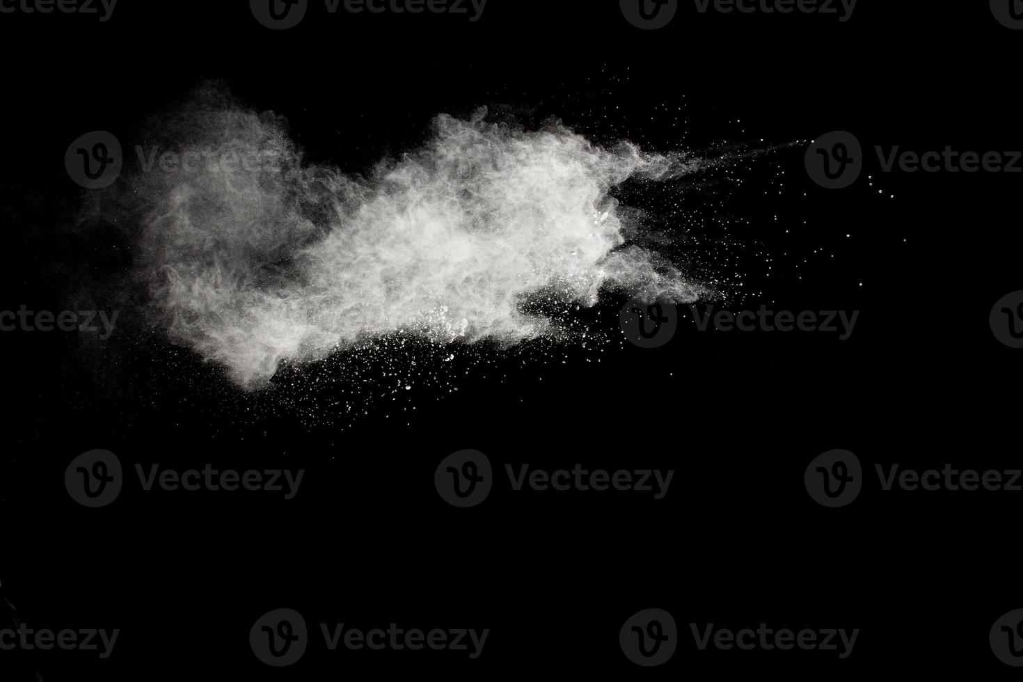 witte poeder explosie clouds.freeze beweging van witte stofdeeltjes spatten op zwarte achtergrond. foto