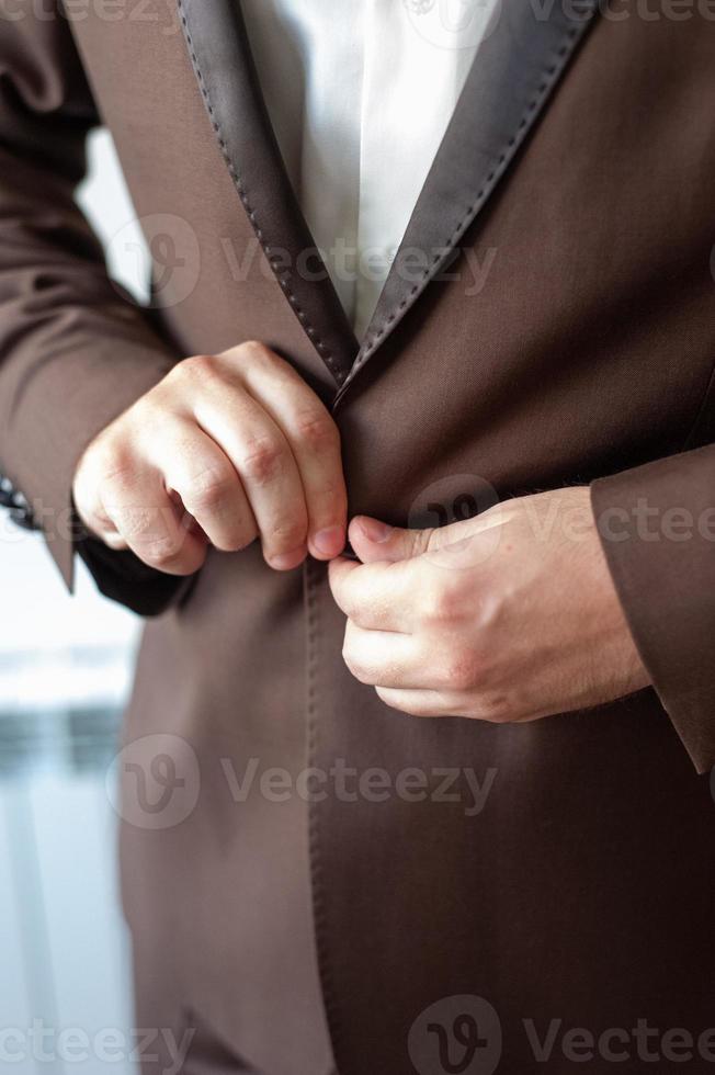een zakenman maakt een knoop op een jas vast. foto