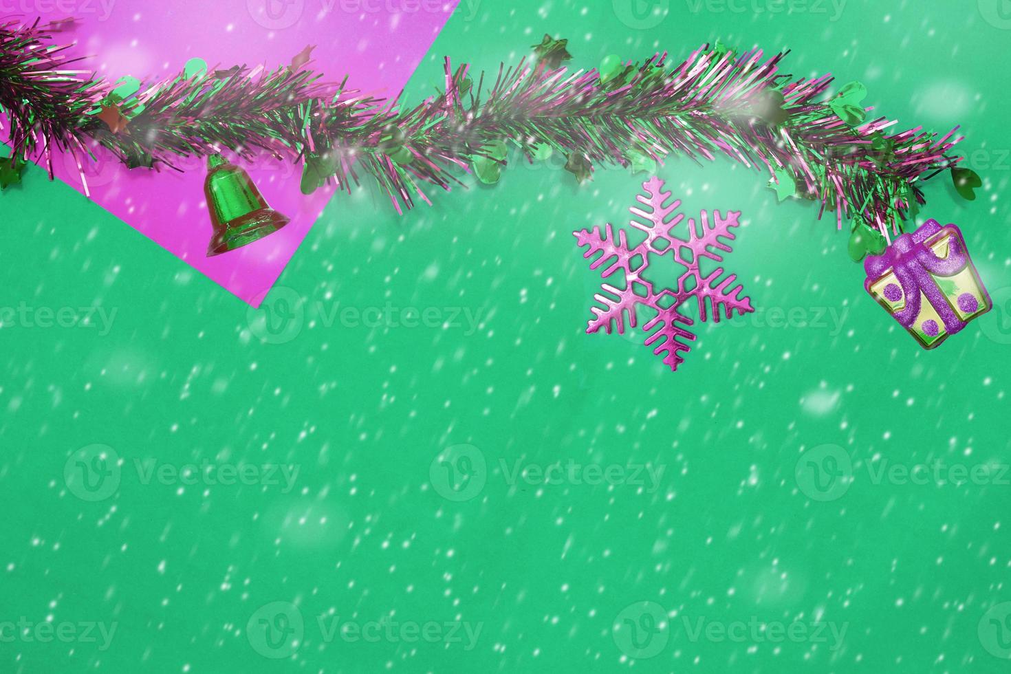 nieuwjaarskwast en cadeau, bel met rode sneeuwvlok op rode en groene achtergrond met kopieerruimte voor kerstmis foto